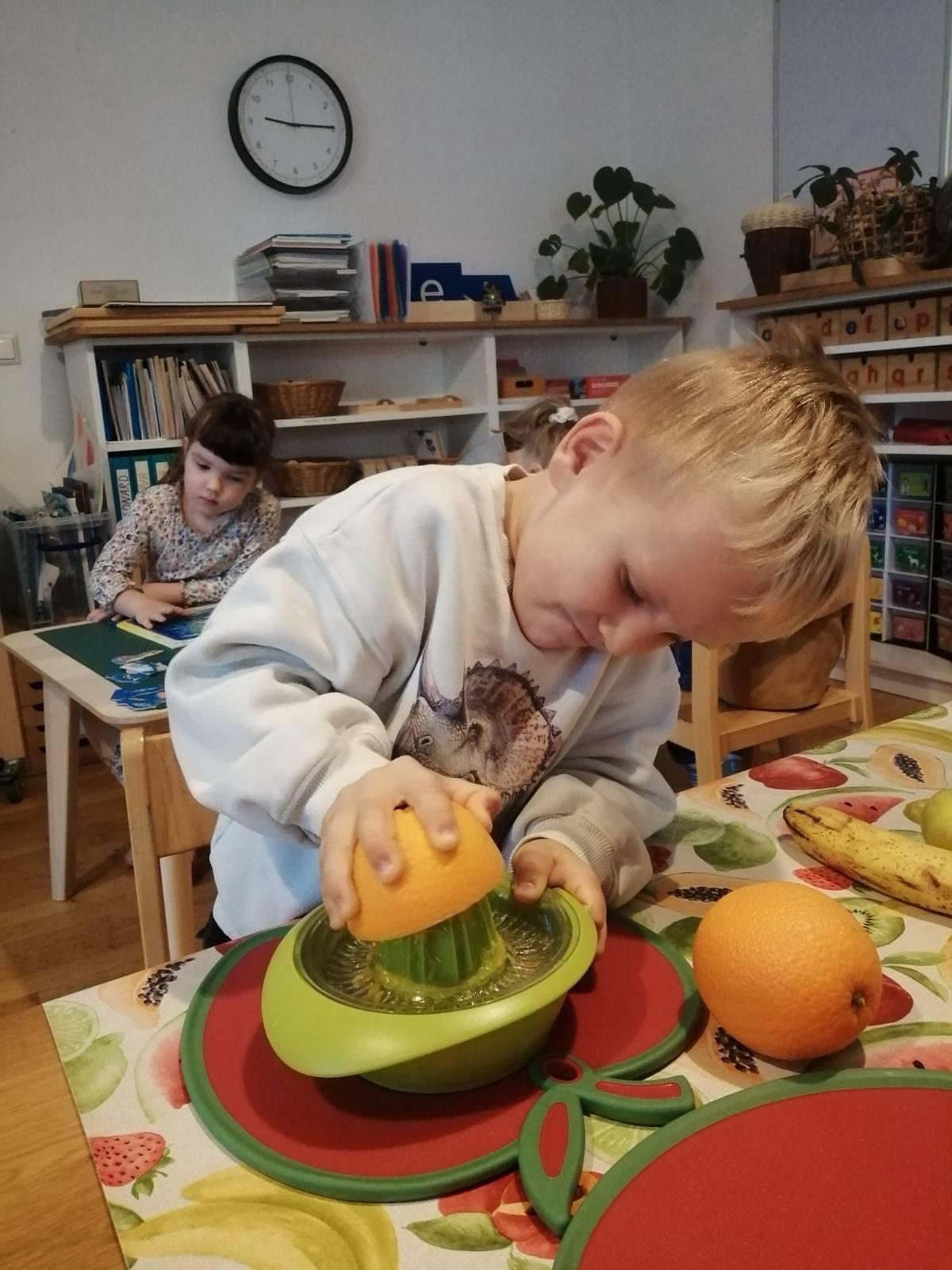 Ein Kind presst selbstständig eine Orange aus
